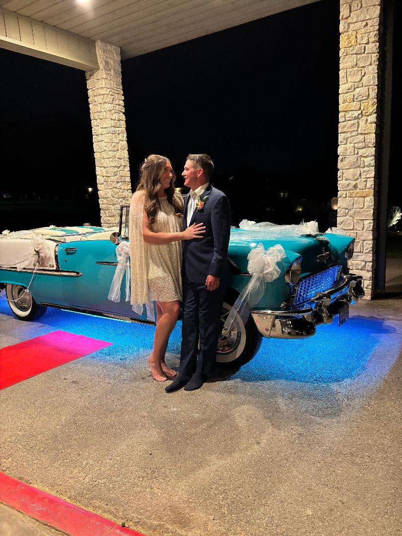Newlywed couple standing together beside decorated Ole' Belle