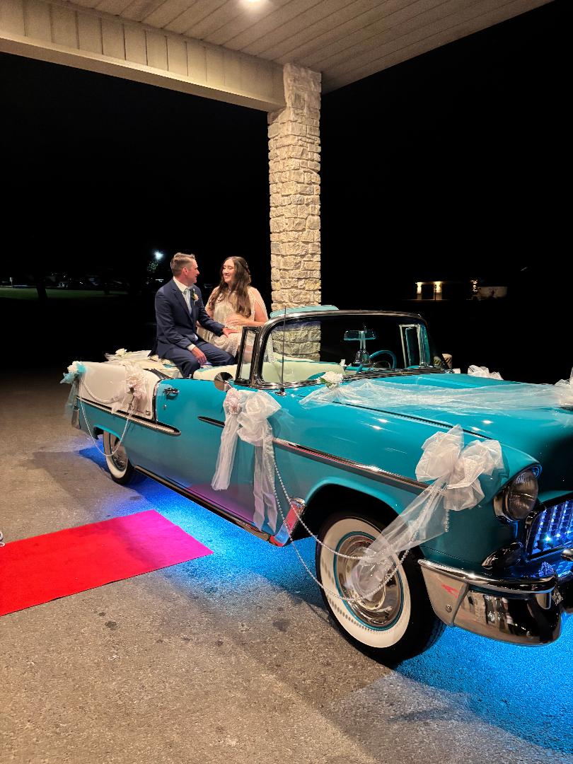 Newlywed couple smiling together in decorated Ole' Belle