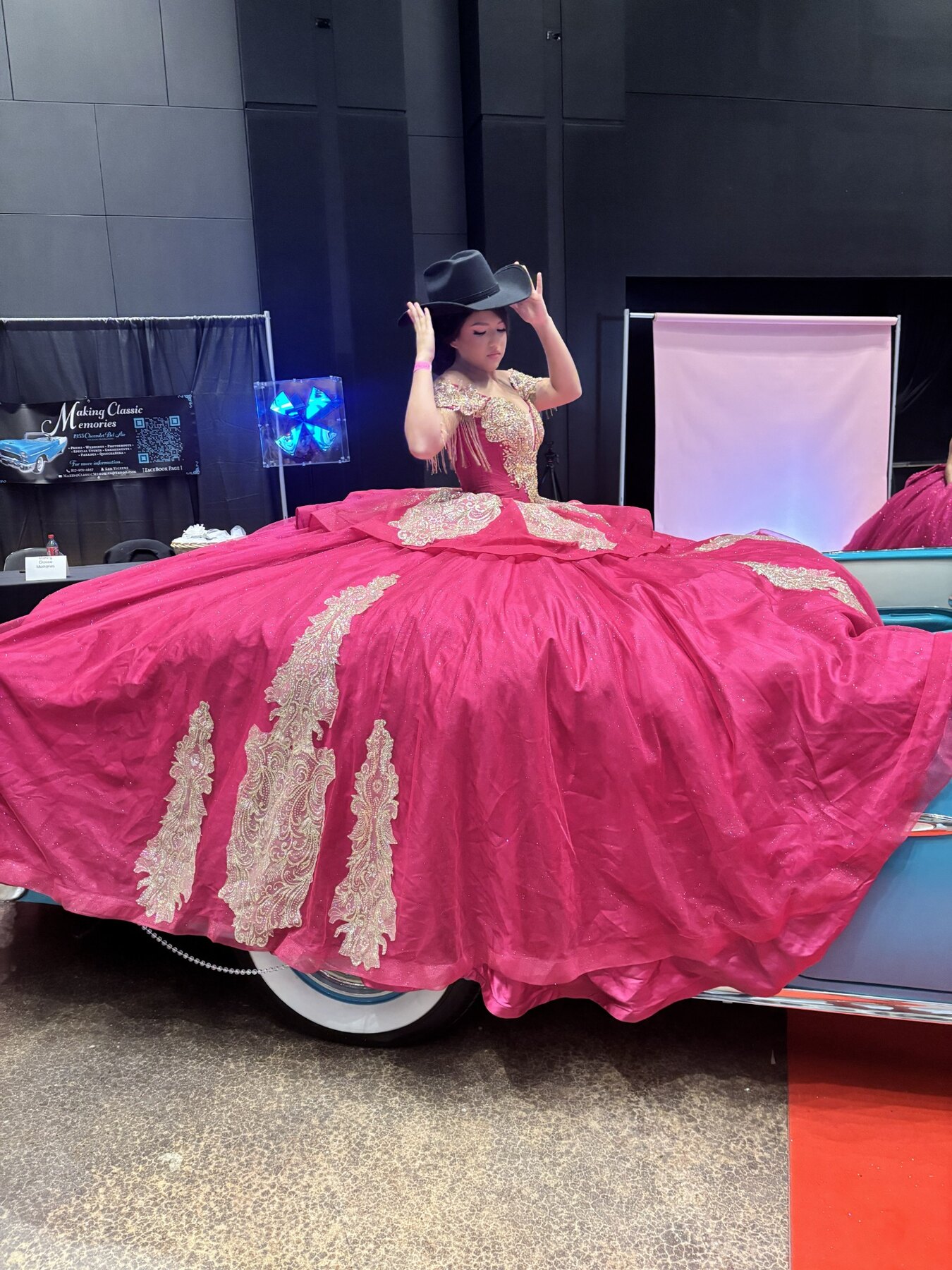 Young woman in a fuchsia quinceañera gown posing beside Ole' Belle